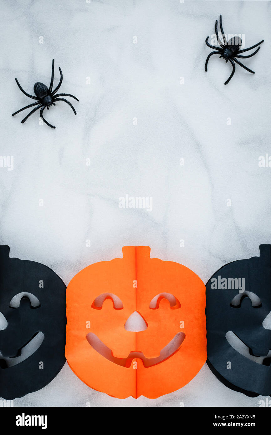 Halloween Hintergrund Papier Kürbis und Spielzeug Spinne. Festliche Karte, Feier. Kopieren Sie Platz. Kunst Dekor. Ansicht von oben. Urlaub Dekoration. Stockfoto