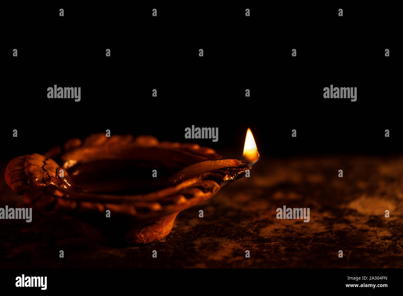 Diwali feier Hintergrund. Religiöse traditionelle beleuchtete diya Öl Ton Lampe während der Indischen festliche Jahreszeit in schwarzer Hintergrund mit Cop isoliert Stockfoto