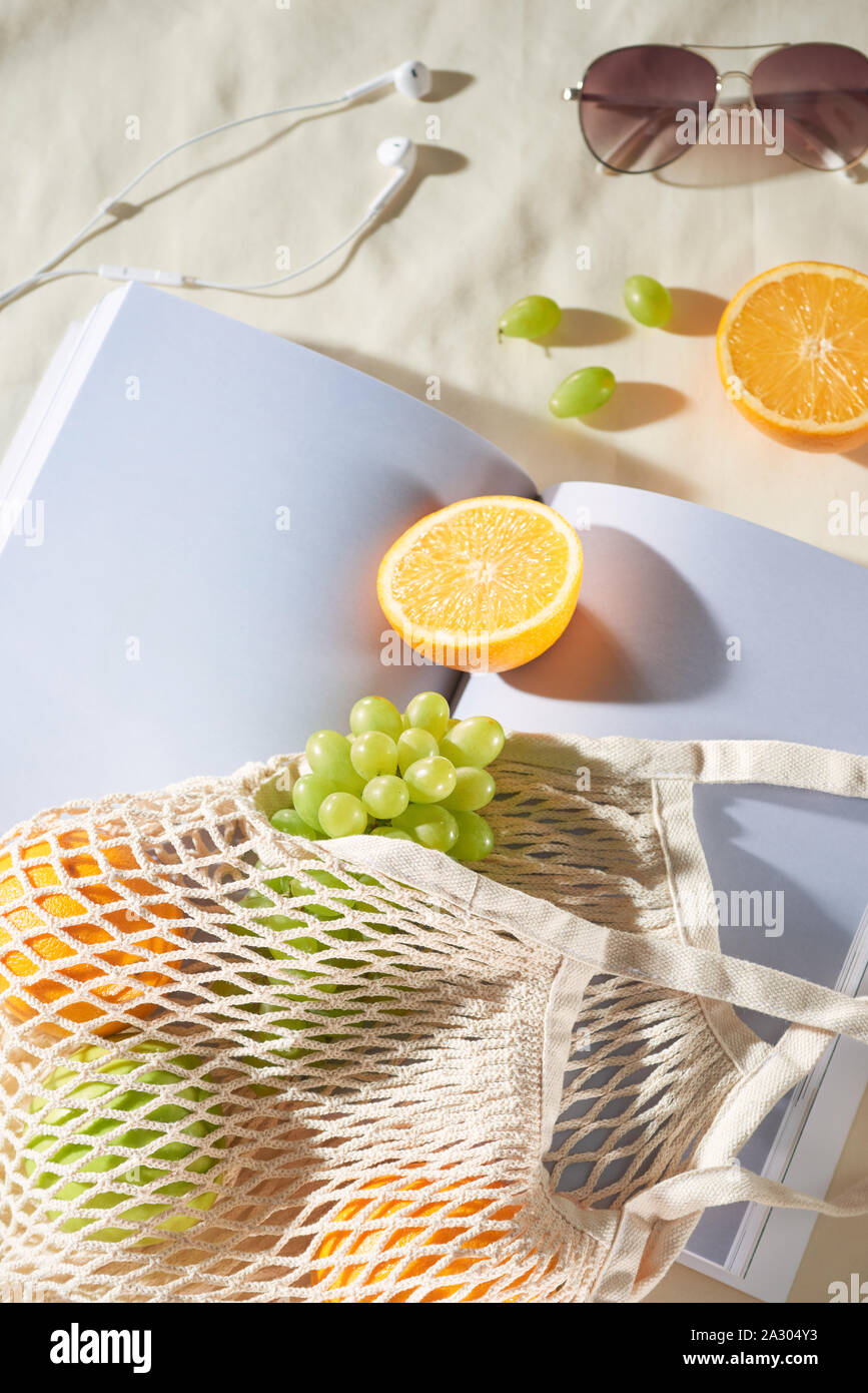 Sommerurlaub mit Obst Beutel, Gläser, Ohrhörer und Magazin auf hellen Hintergrund. Stockfoto