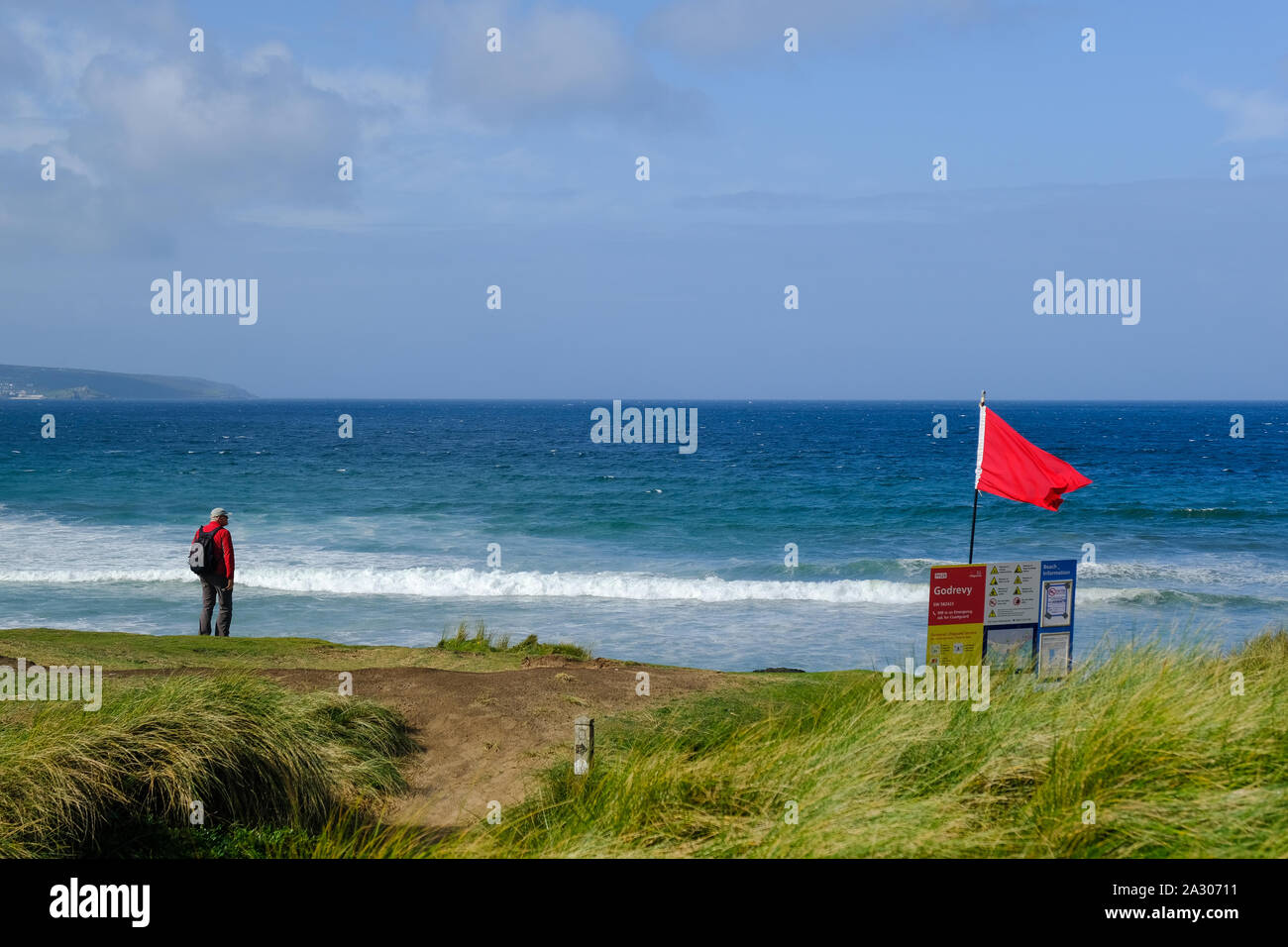 Eine rote RNLI Lifeguards Warnung Fahne über den Strand fliegen an Godrevy in Cornwall. Stockfoto