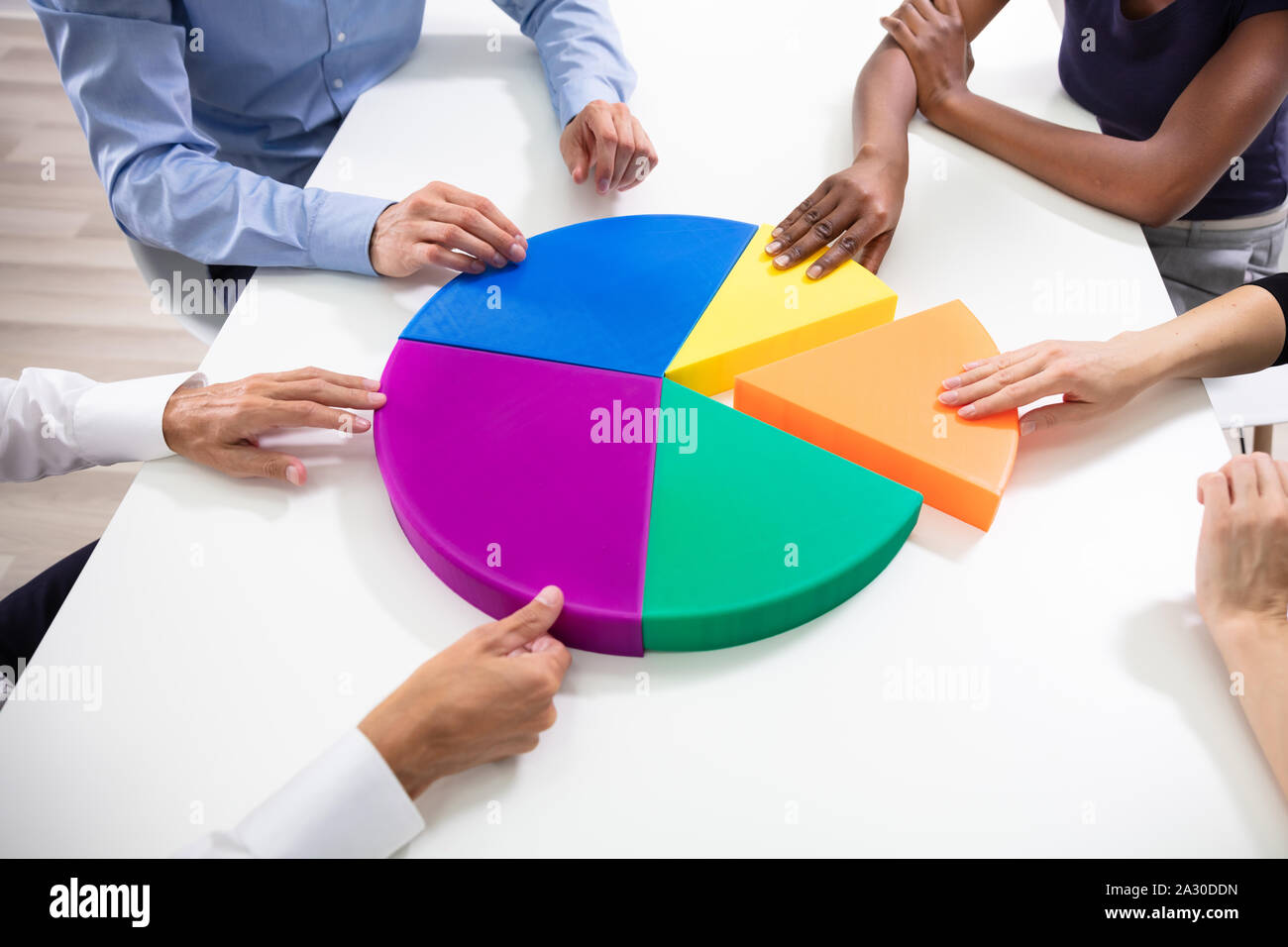 Hohe Betrachtungswinkel der Geschäftsleute Hände Mit Bunten Stücke des Kreisdiagramms Stockfoto