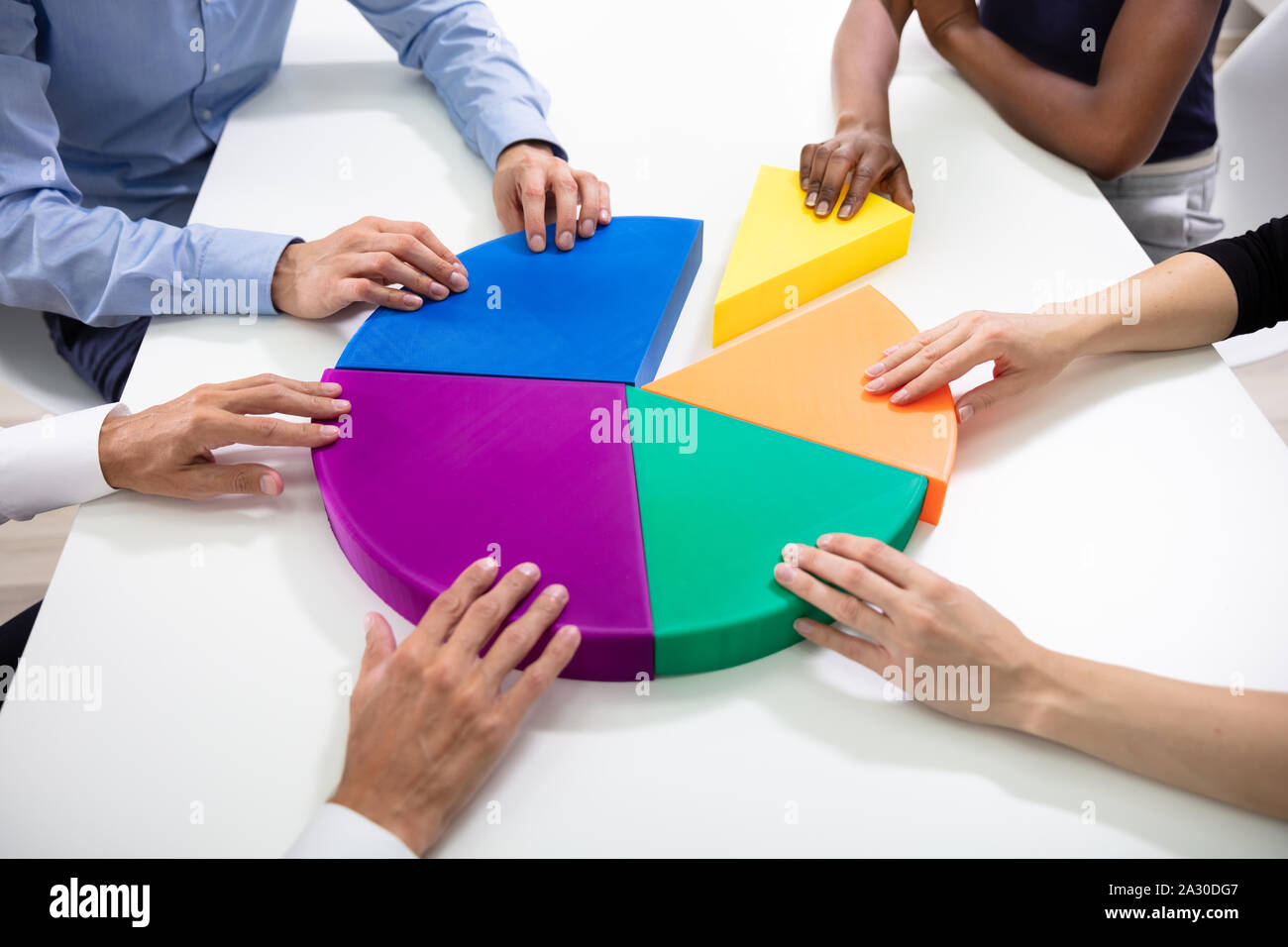 Hohe Betrachtungswinkel der Geschäftsleute Hände Mit Bunten Stücke des Kreisdiagramms Stockfoto