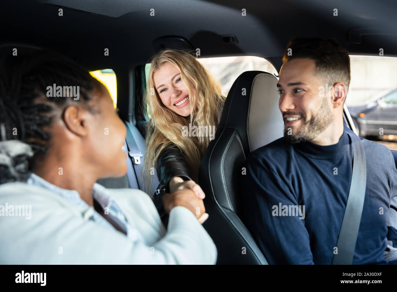 Glückliche Menschen an weibliche Freunde Hände schütteln im Auto suchen Stockfoto