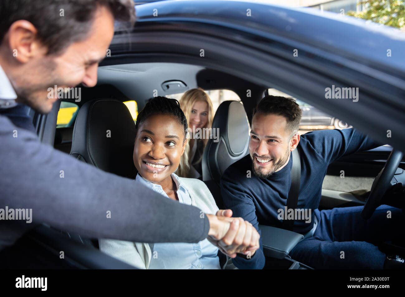 Mann Schütteln Hanks mit Freunden Sitzen im Auto durch das Fenster Stockfoto