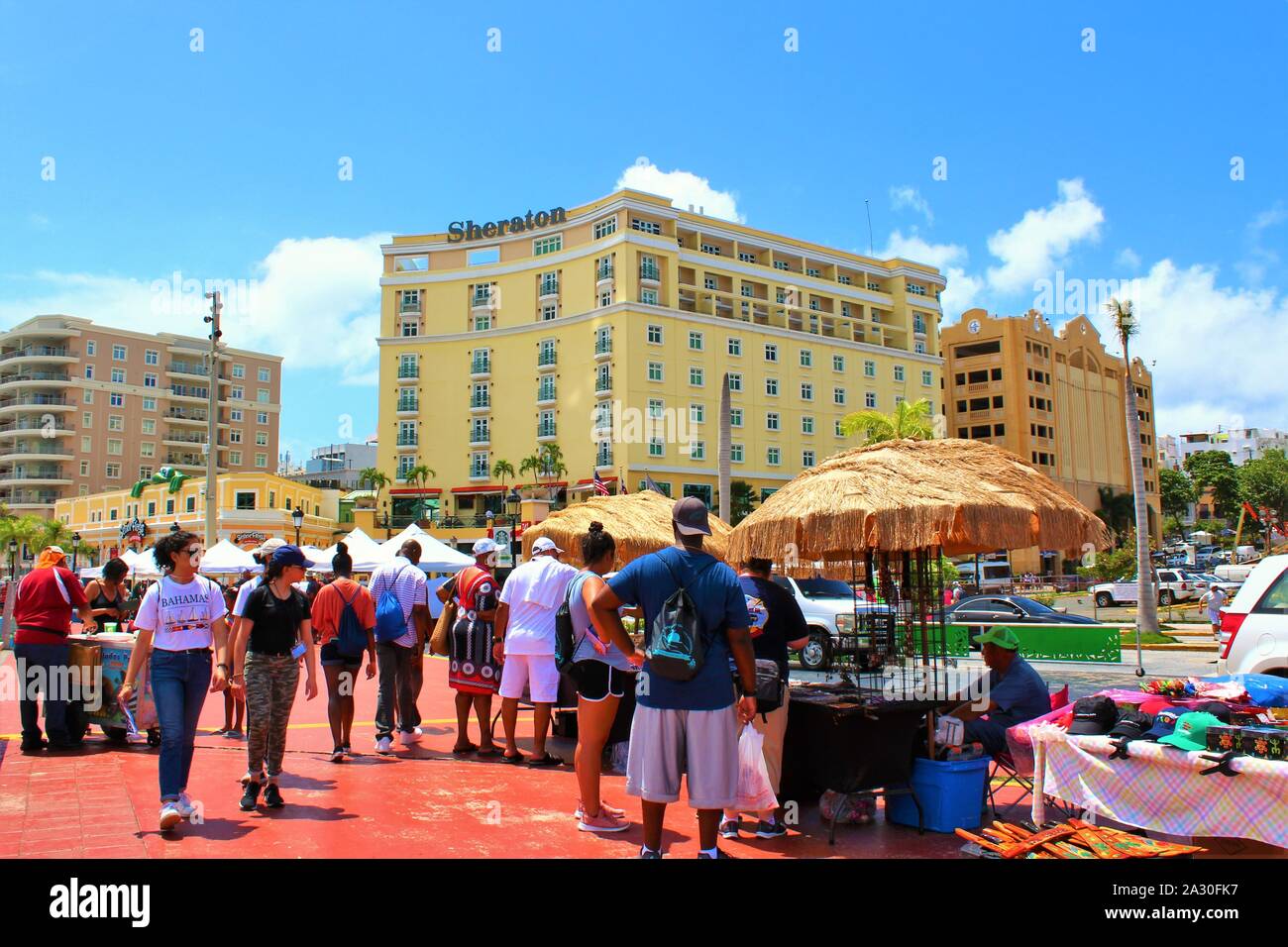 Touristen aus dem angedockten Kreuzfahrtschiffe durchsuchen die Souvenirstände entlang der Promenade direkt vor der Kreuzfahrt am Hafen von San Juan. Stockfoto