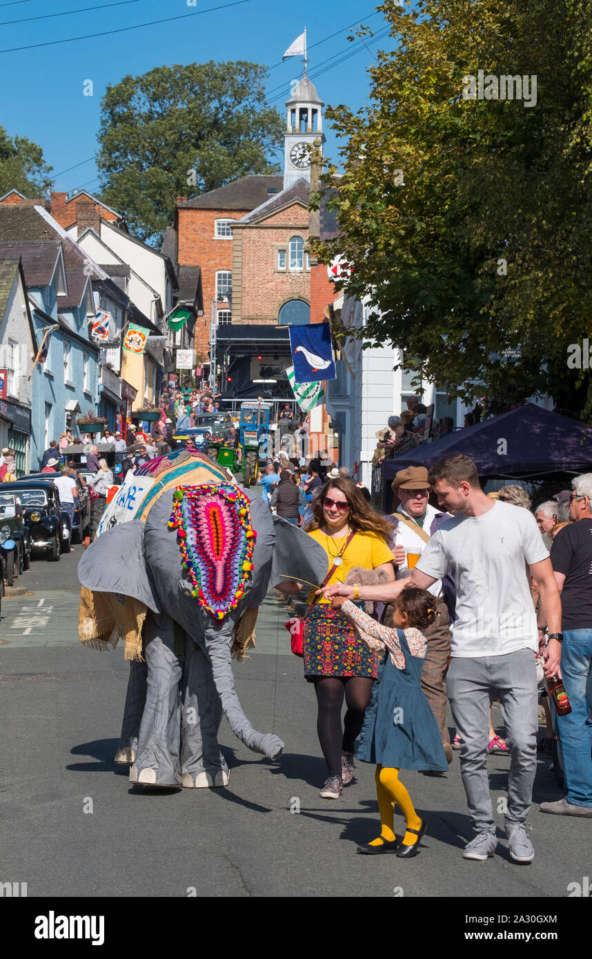 In einer Prozession, die High Street in des Bischofs Schloss Michaelmas Fair, Shropshire, England, UK Elephant Stockfoto