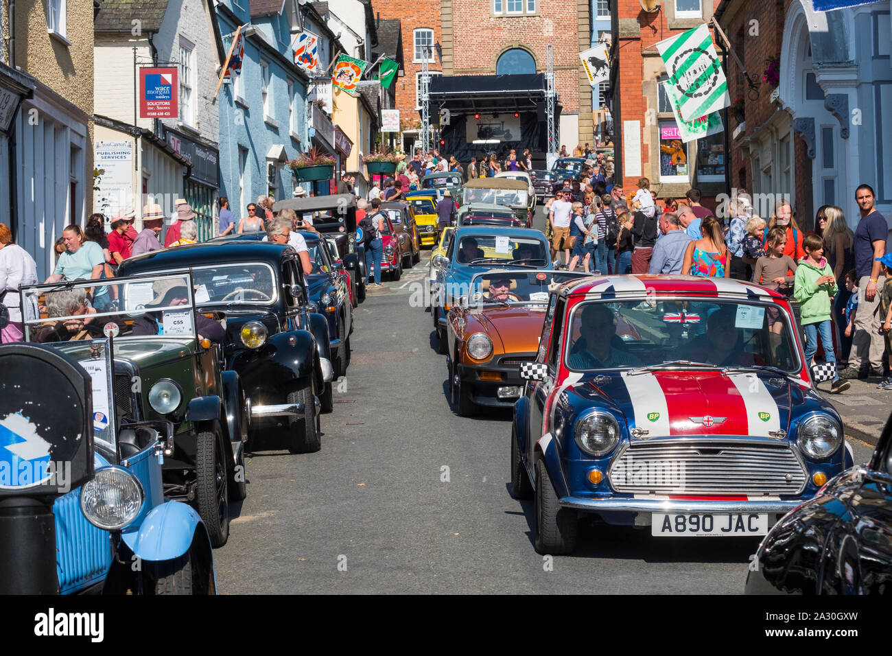 Klassische Autos, darunter eine rote, weiße und blaue Mini parade Hohe Straße des Bischofs Schloss Michaelmas Fair, Shropshire, England, Großbritannien Stockfoto
