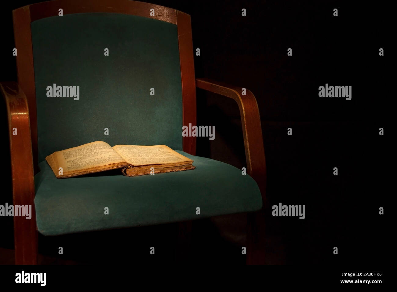 Alten Stuhl und offenes Buch in einem dunklen Stockfoto Alten Stuhl und offenes Buch in einem dunklen Stockfoto