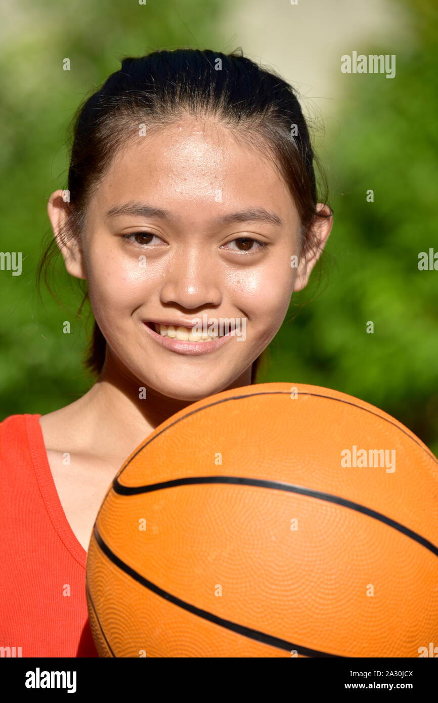 Lächelnd ziemlich Filipina weiblichen Athleten mit Basketball Stockfoto