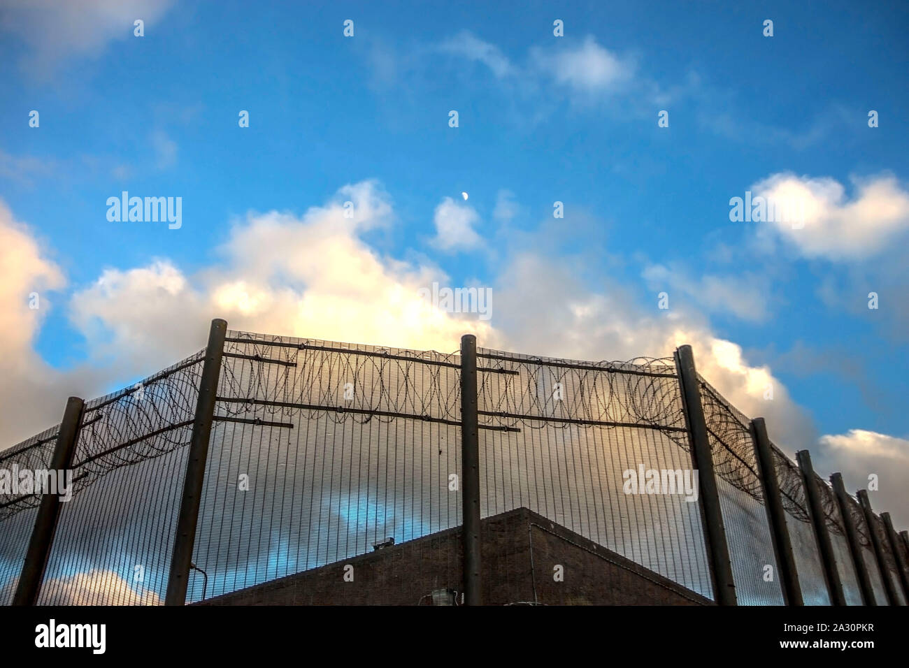Gefängnismauern und einen Zaun mit Spikes auf dem Hintergrund des blauen Himmels. Peterhead Gefängnis Museum, Aberdeenshire, Schottland, Vereinigtes Königreich. Stockfoto