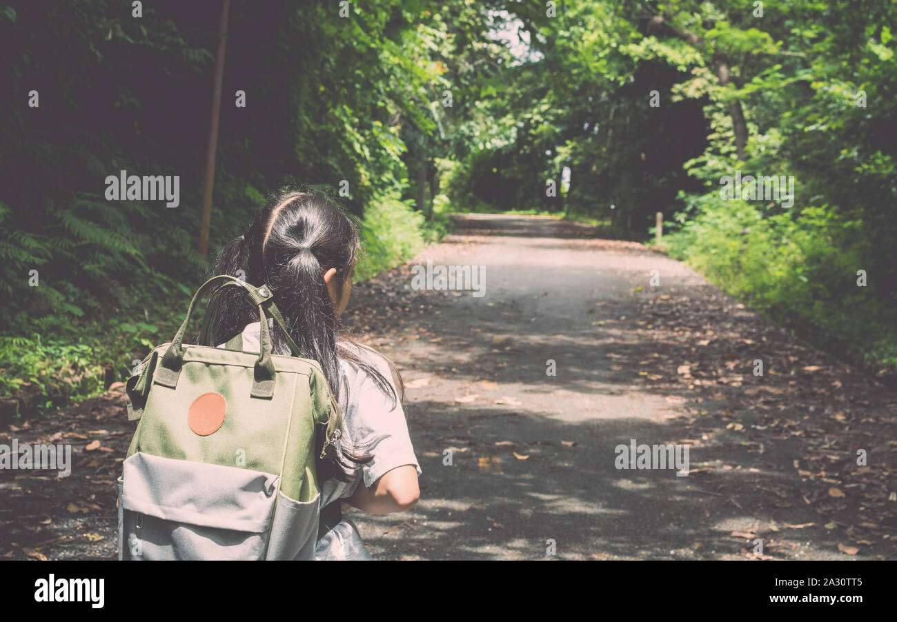 Mädchen mit Rucksack wandern auf dem Hügel in tropischen Wald. Stockfoto