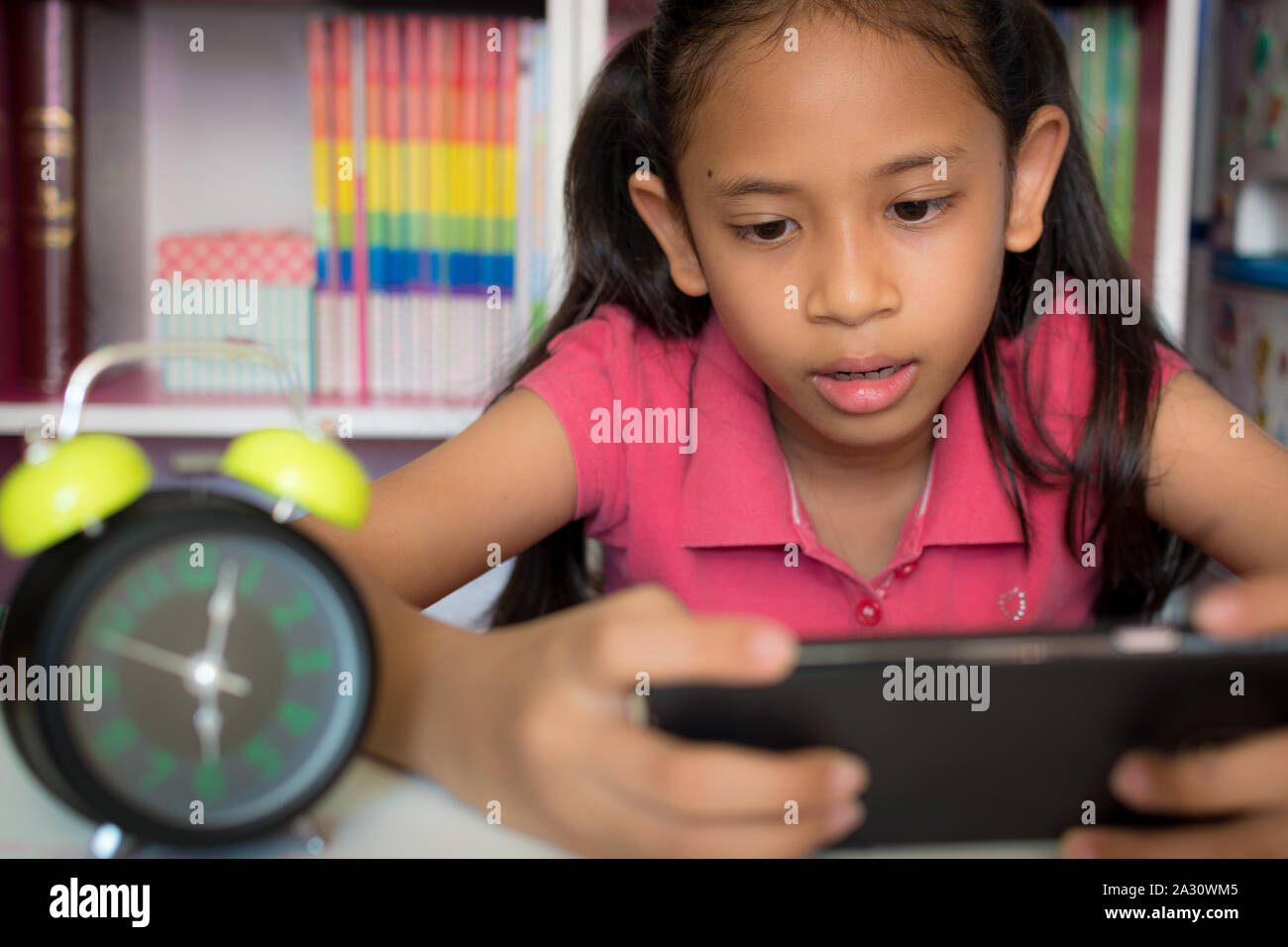 Kleines Mädchen mit Handy mit Wlan zu Hause. Bildung Konzept. Stockfoto
