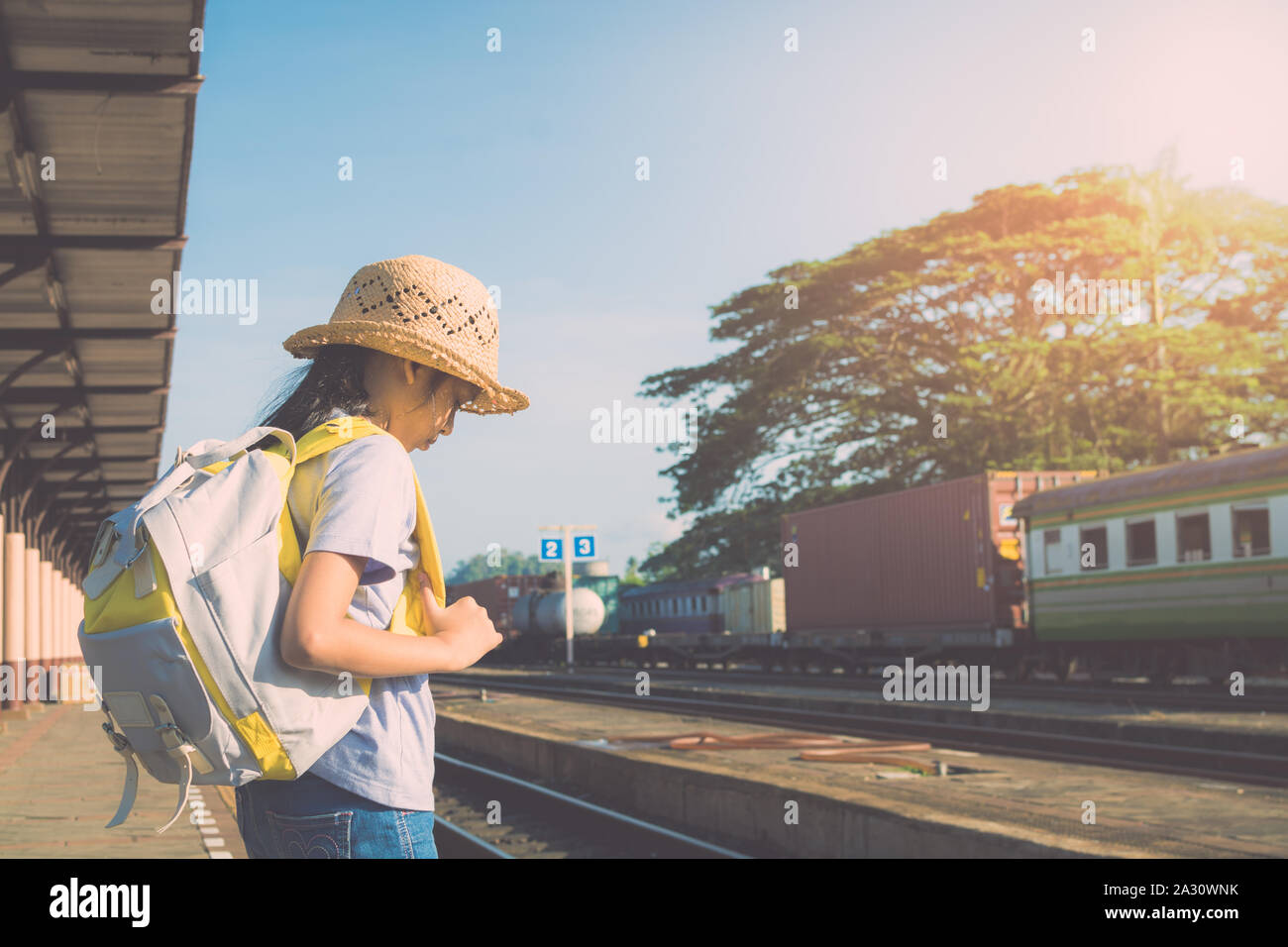 Junges Mädchen mit Rucksack für einen Zug am Bahnhof im Sommer warten. Stockfoto