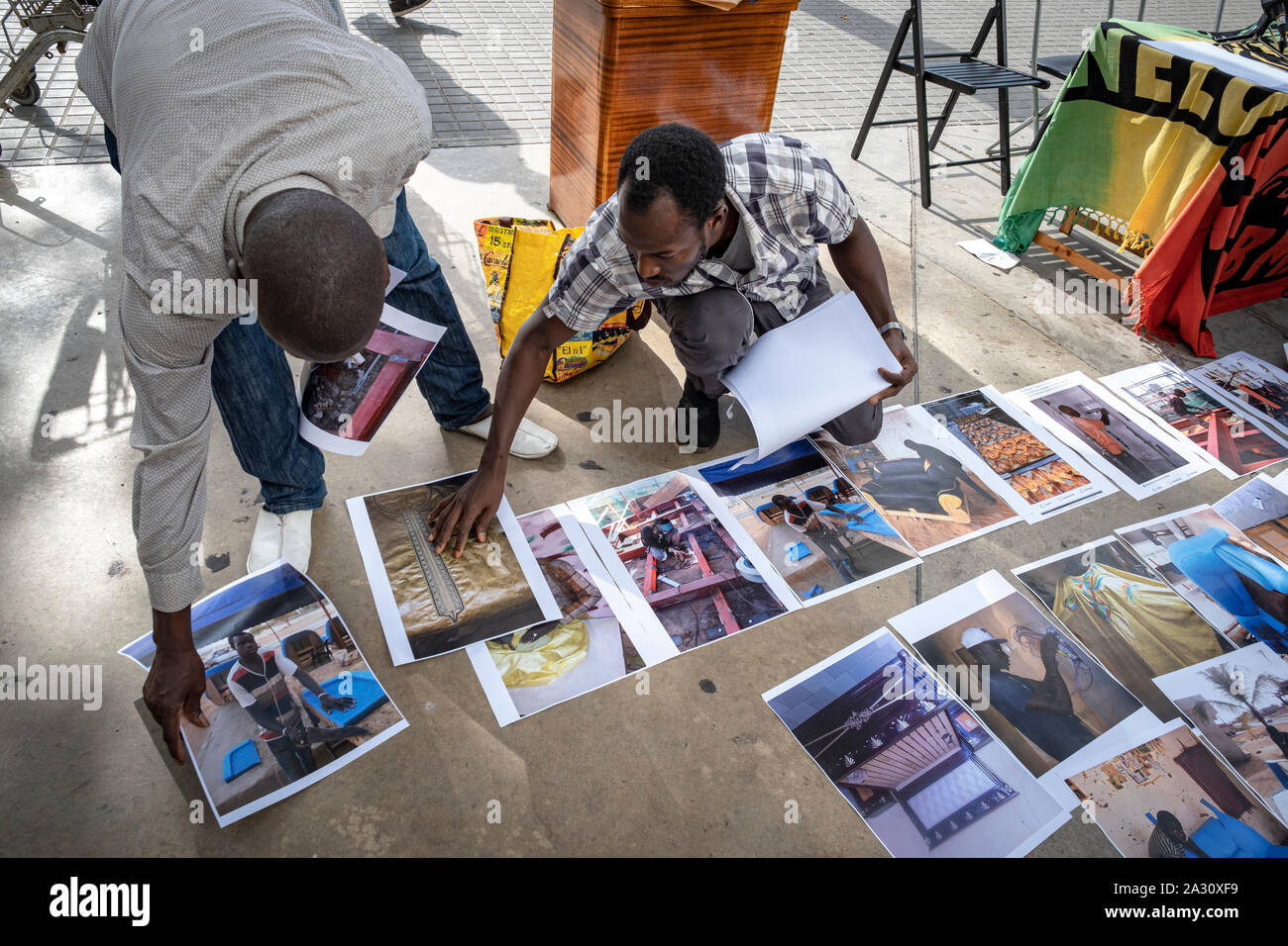 Barcelona, Spanien. 04 Okt, 2019. Straßenhändler Ort Porträts auf dem Boden während der Pressekonferenz. Straßenhändler, bekannt als "anteros" für ihre Waren verkaufen, in der Straße auf einer Decke, haben eine Pressekonferenz zu denunzieren, dass sie unter dem Druck der Polizei seit mehreren Monaten haben, die verhindert, dass Sie den Verkauf und die Herstellung eines Lebens genannt. Credit: SOPA Images Limited/Alamy leben Nachrichten Stockfoto