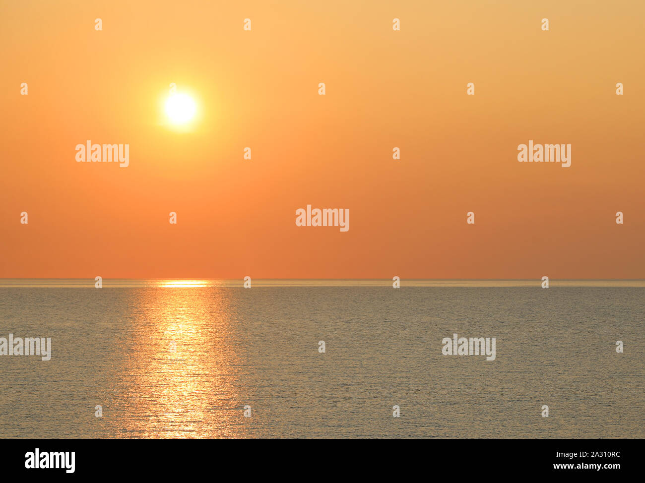 Heiße gelbe Sonne über dem Meer bei Sonnenuntergang Stockfoto