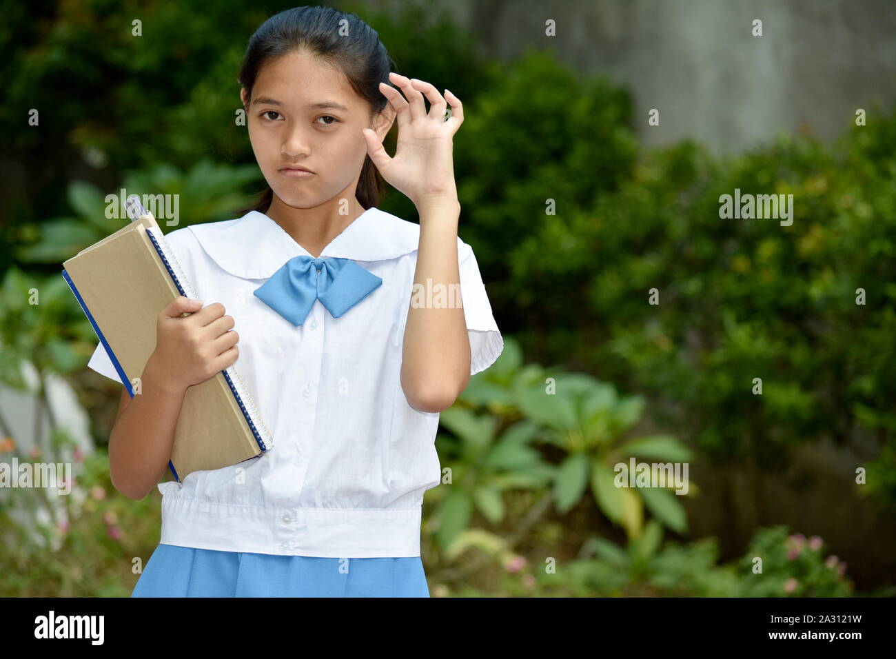 Einschüchternd junge Filipina Person mit Schule Bücher Stockfoto