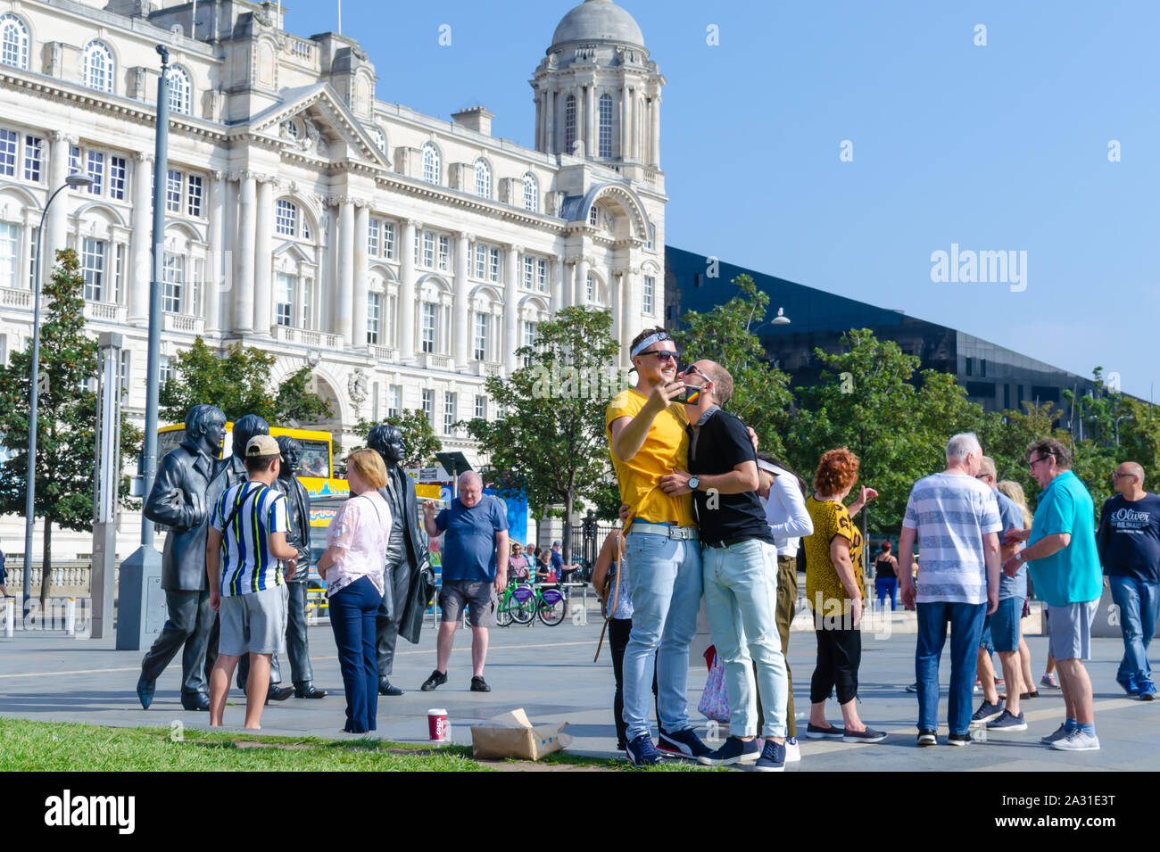 Bronze Statuen der vier Beatles in Liverpool, Großbritannien, und ein homosexuelles Paar, das unter Berücksichtigung der selfie sind mit Ihnen. Zeigt die Vielfalt unter den Fans der Band. Stockfoto