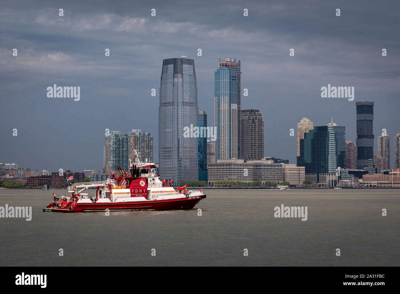 Ein New York City Feuerwehr Boot patrouilliert den Hafen in der Nähe der Freiheitsstatue. Stockfoto