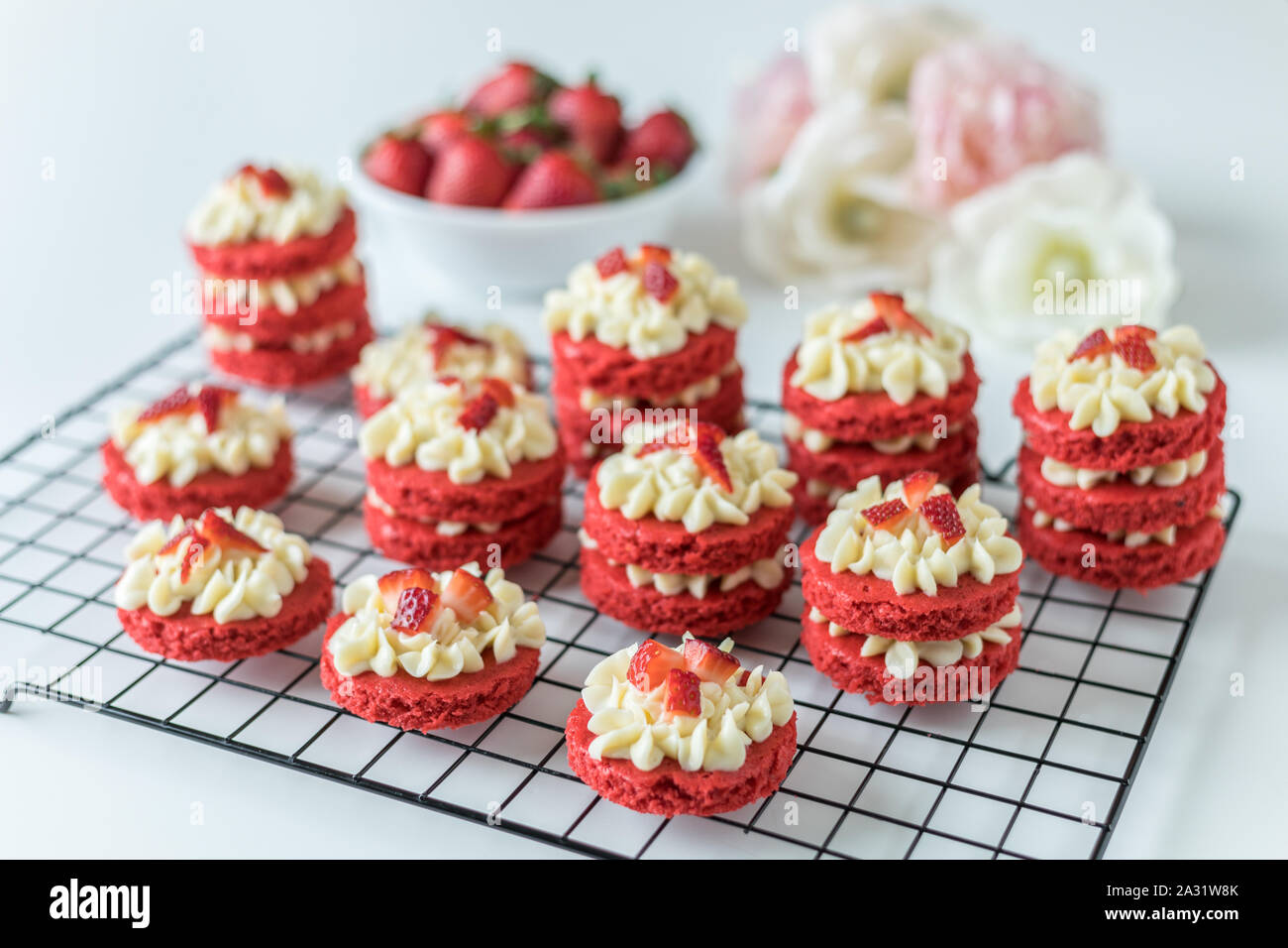 Miniatur Red Velvet Kuchen mit Cream Cheese frosting und frische Erdbeer Topping auf eine Kühlung Rack Stockfoto