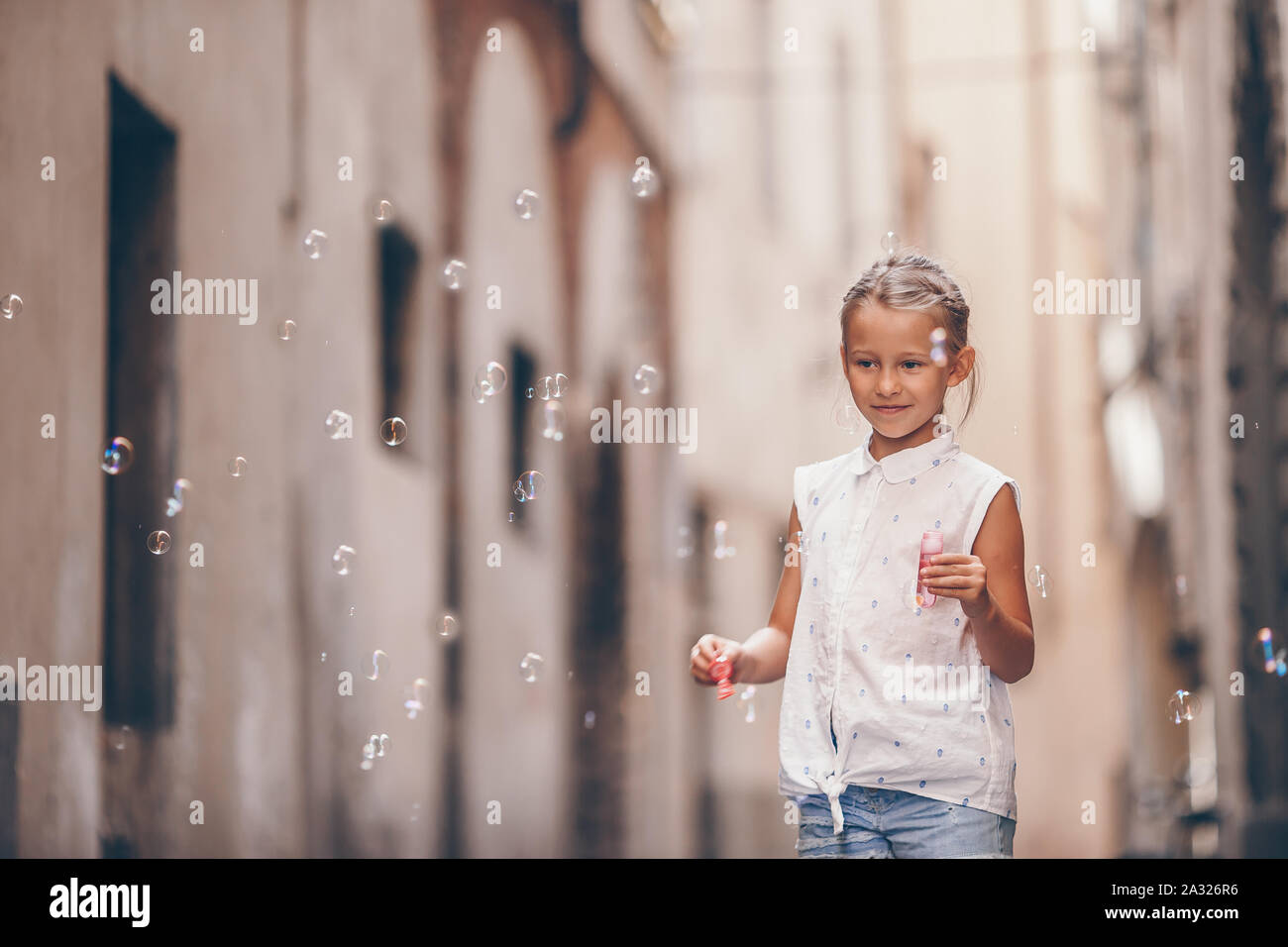 Entzückende kleine Mädchen im freien Seifenblasen in europäischen Städten. Porträt des kaukasischen Kind genießen Sommerurlaub in Italien Stockfoto