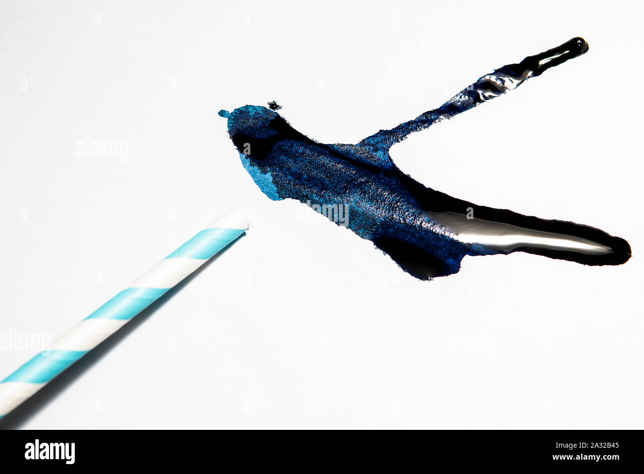 Blaue Tinte von einem Stroh auf weißem Papier geblasen Stockfoto
