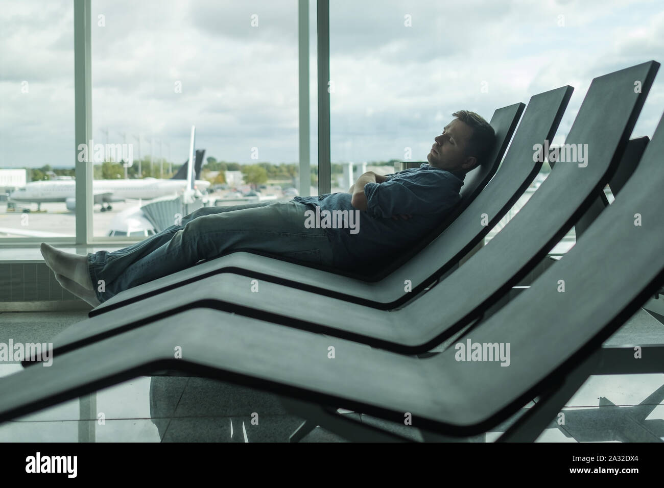 Reifer Mann im Flughafen schlafen auf einer Werkbank Stockfoto