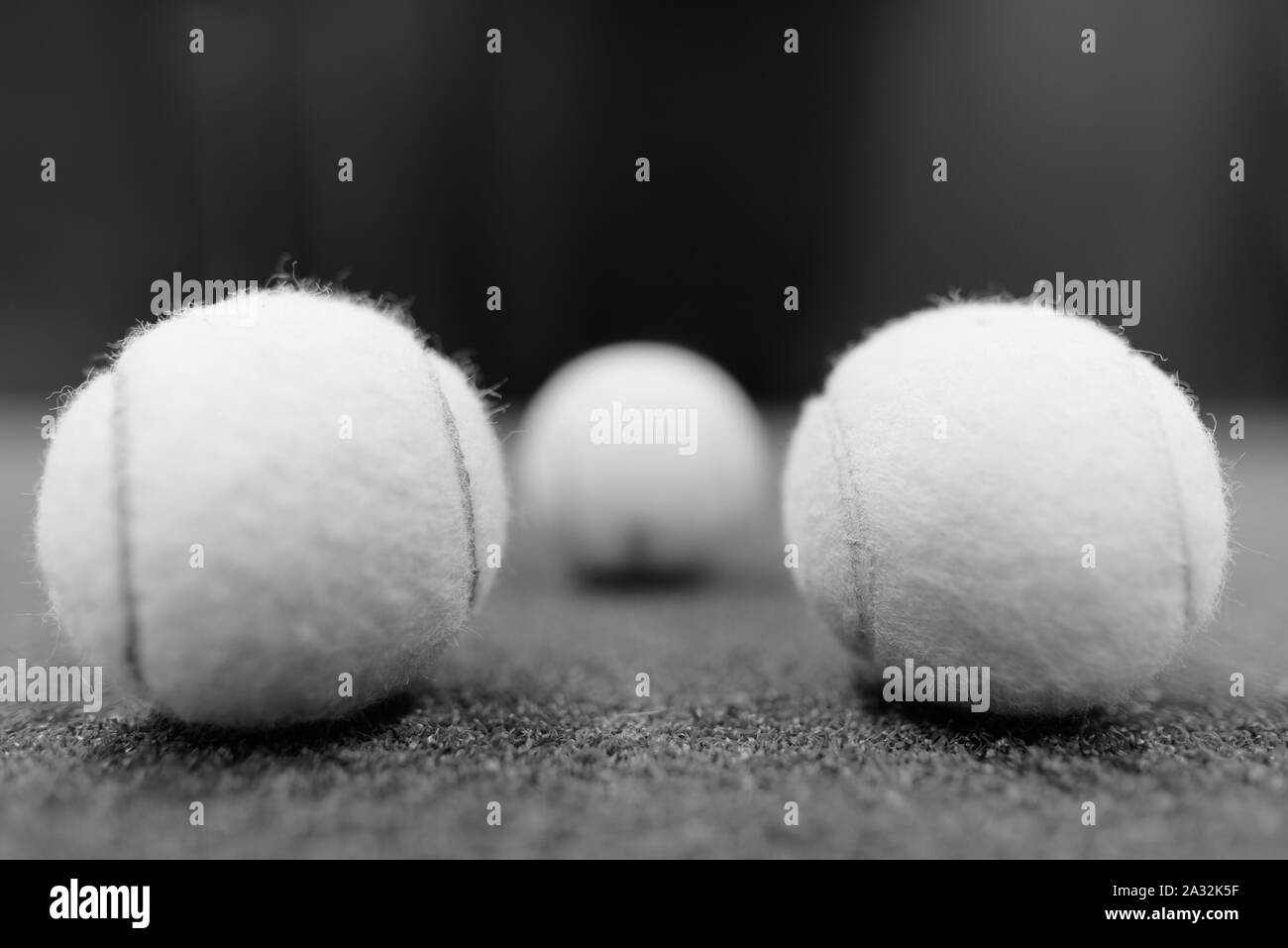 Tennis Bälle auf dem Boden geschossen in Schwarz und Weiß Stockfoto