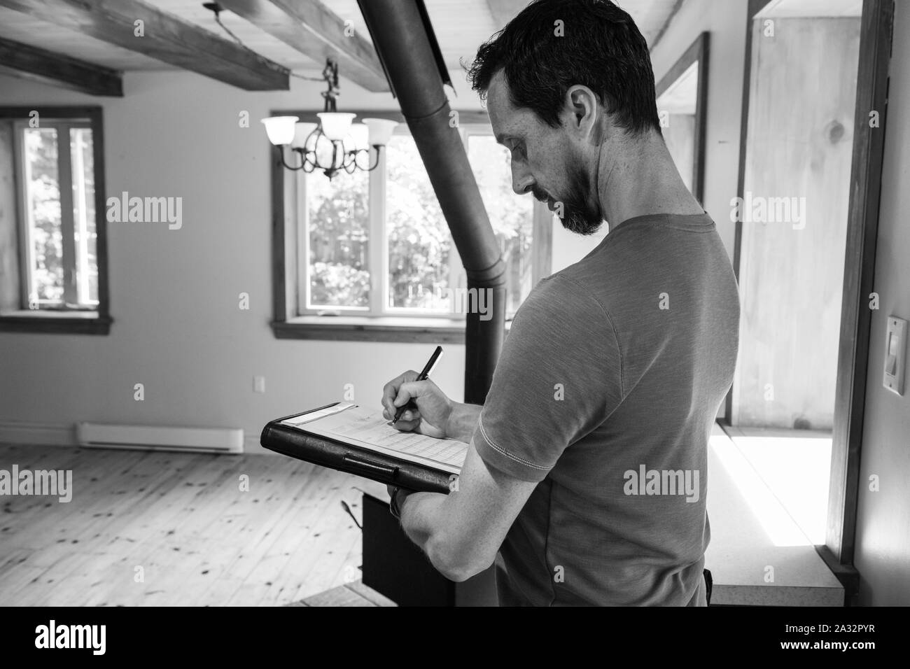 Ein monochromes und seitlichen Profil Ansehen eines Mannes, der die Durchführung einer professionellen Umwelt Luft und Feuchtigkeit Bewertung innerhalb eines inländischen Gebäude mit kopieren. Stockfoto