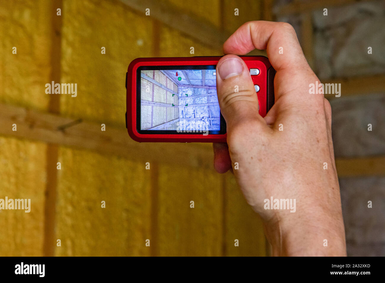 Eine Sicht der Perspektive der Innenraumqualität (IEQ) Surveyor bei der Arbeit mit einer Digitalkamera zu fotografieren Glasfaser isolierte Wände. Stockfoto