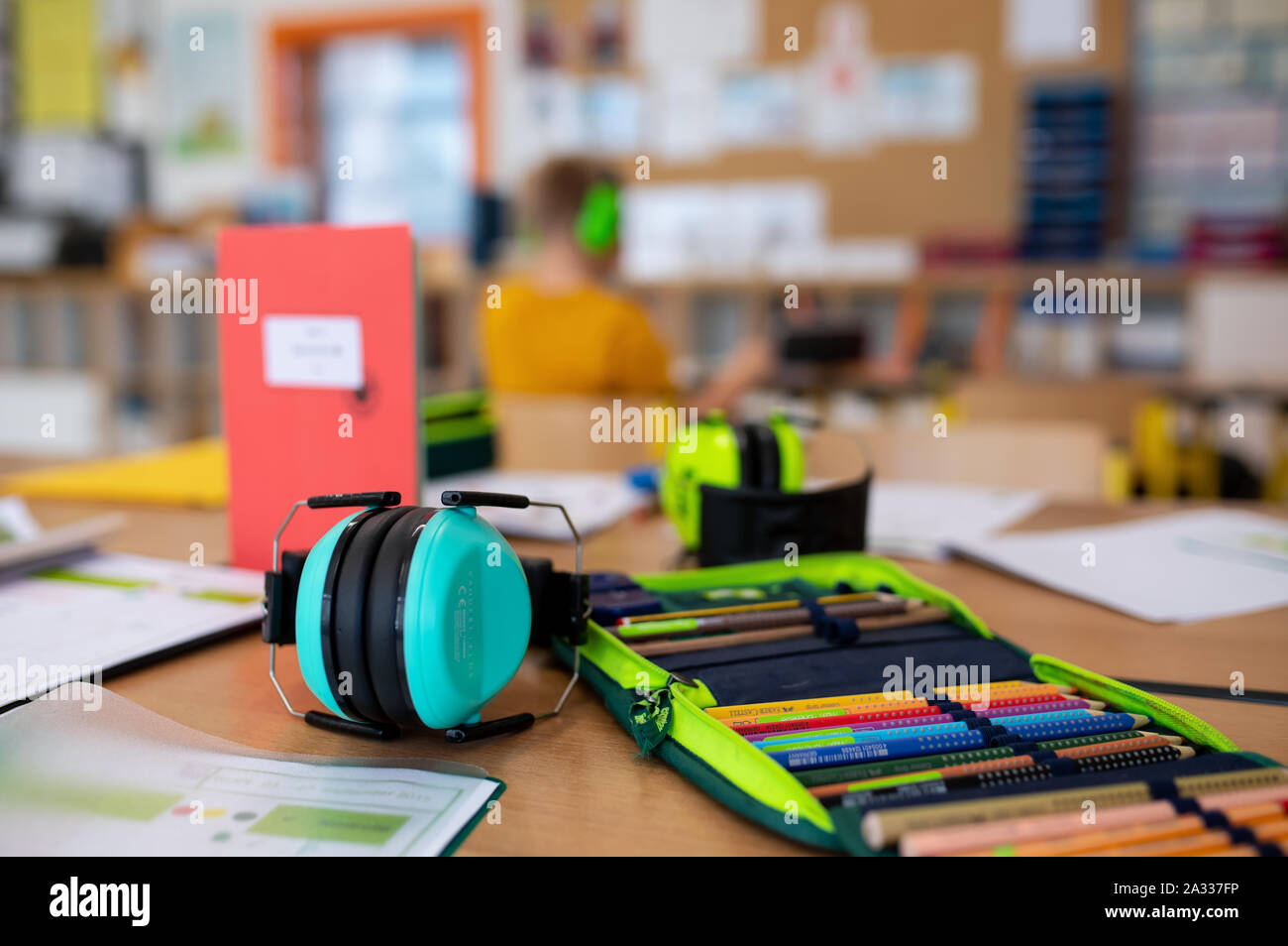 München, Deutschland. 24 Sep, 2019. Ein Federmäppchen und Gehörschutz liegen auf einem Tisch im Klassenzimmer einer 2.Klasse einer Grundschule. Aufgrund der fehlenden Lehrer in Bayern, immer weniger voll ausgebildete Sonderpädagoginnen lehren an den Sonderschulen. Credit: Sven Hoppe/dpa/Alamy leben Nachrichten Stockfoto