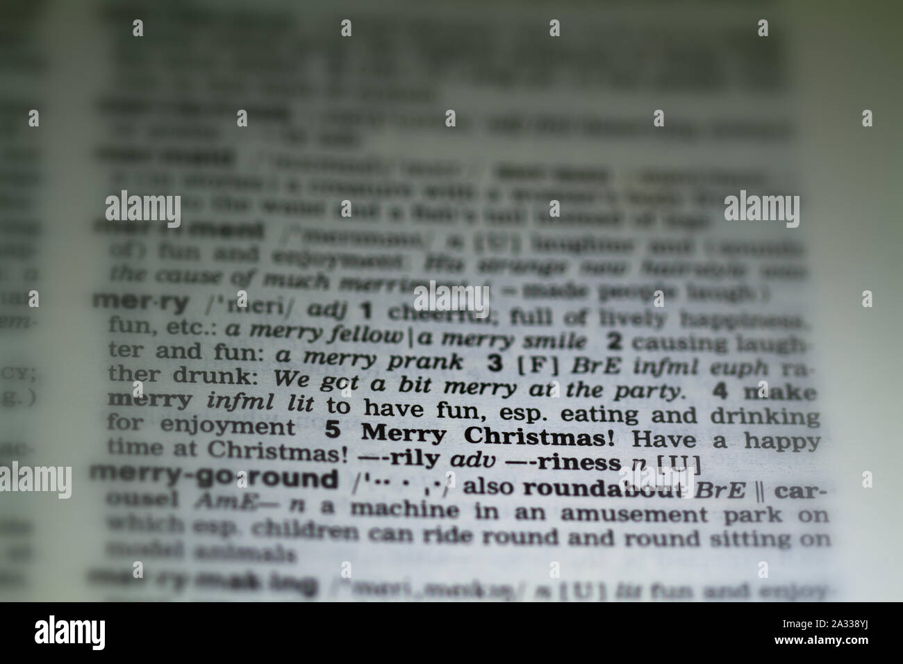 Das Wort frohe Weihnachten Definition in alte Wörterbuch unter der Lupe Stockfoto