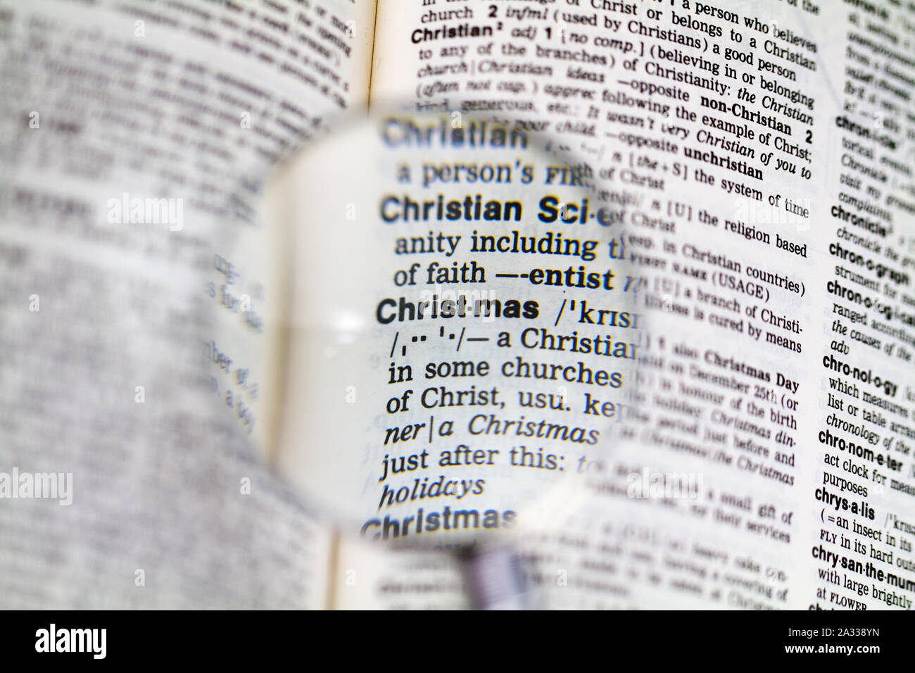 Das Wort frohe Weihnachten Definition in alte Wörterbuch unter der Lupe Stockfoto