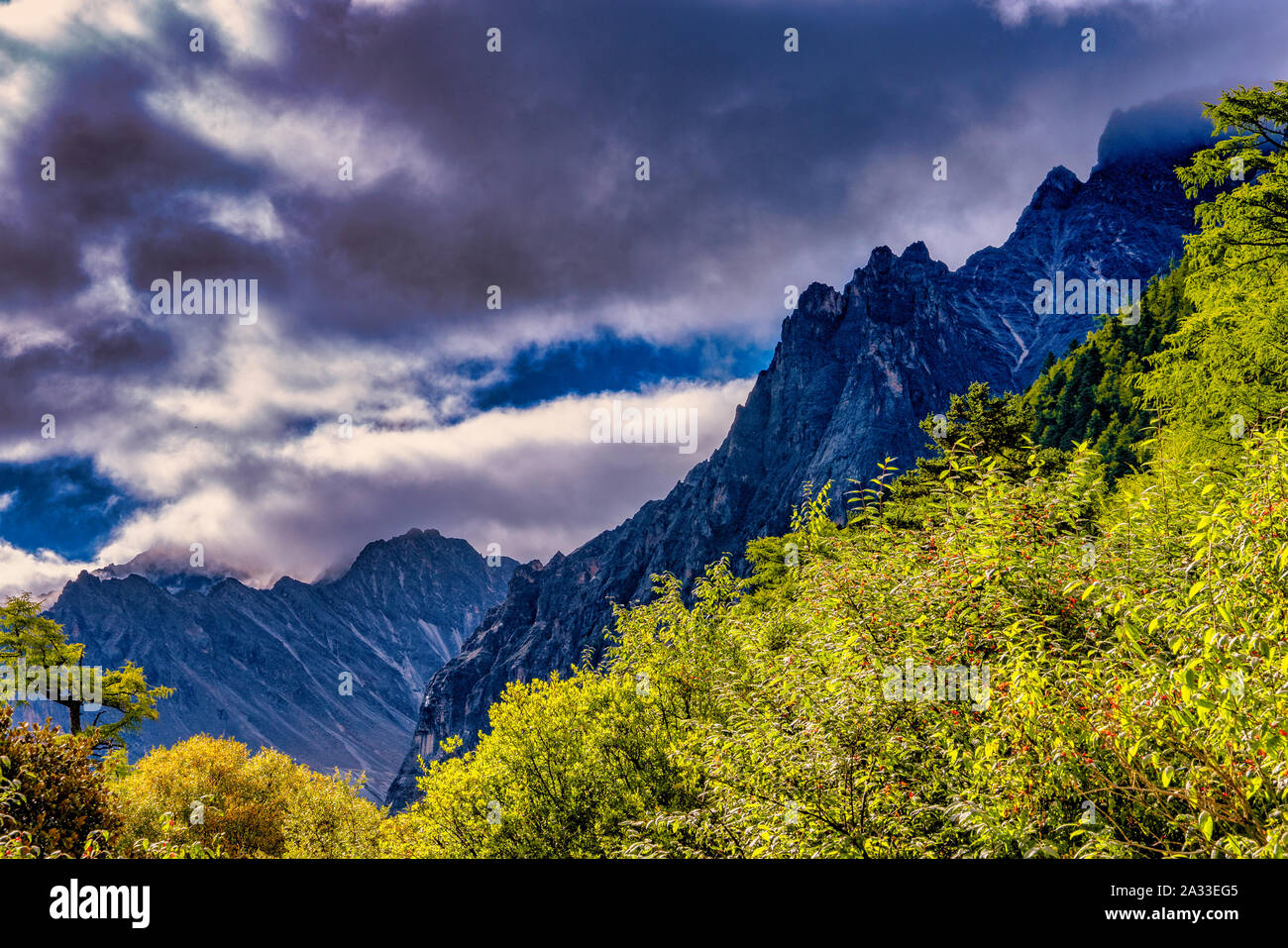 Berge gegen dramatische Wolken am Nachmittag im Herbst in yading Nature Reserve Nationalpark in China Stockfoto