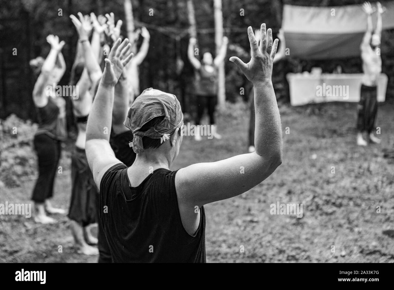 Ein Schwarz/Weiß-Sicht auf eine Gruppe von Menschen, die schamanische Basis Meditation während einer mindfulness Retreat in den Wald, mit copy-Platz. Stockfoto