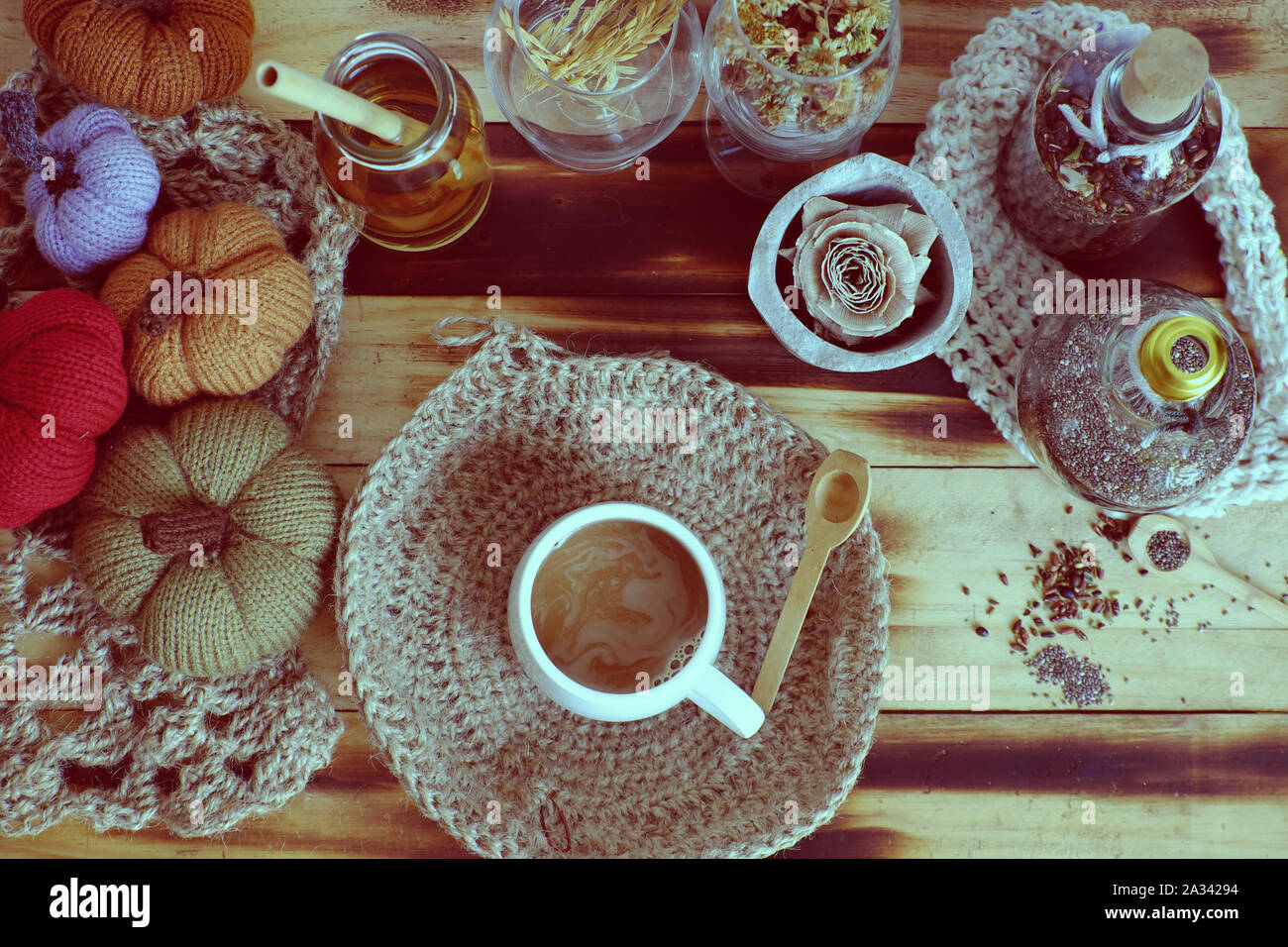 Top-Ansicht Frau Hand halten Morgen Kaffeetasse auf Herbst Hintergrund mit Dekor saisonale Ornament Tisch für Heimdekor als Kürbis, Burlap Gericht Tuch Stockfoto