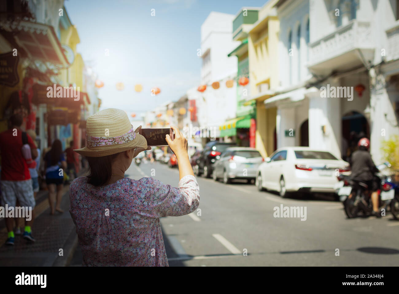 Frau Traveler in legerer Kleidung unter Bild in Thalang Road mit unscharfen Chino portugiesischen Stil Gebäude unter Sonnenlicht Ansicht von hinten. Phuket, Th Stockfoto