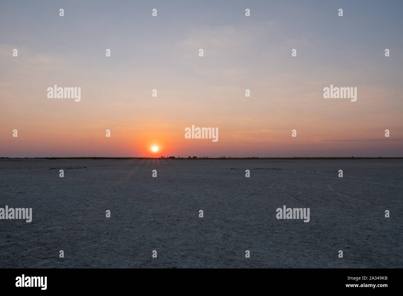 Sonnenuntergang in der makgadikgadi Salzpfanne - Horizont im romantischen Abenddämmerung - Leere flache Ebene, farbenfrohen Himmel bei Twylight mit der untergehenden Sonne Stockfoto