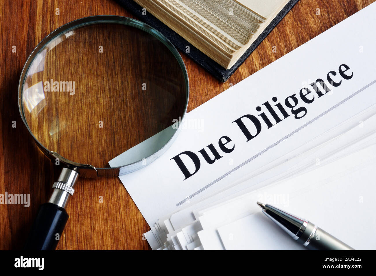 Due Diligence Konzept. Stapel von Dokumenten und Lupe. Stockfoto