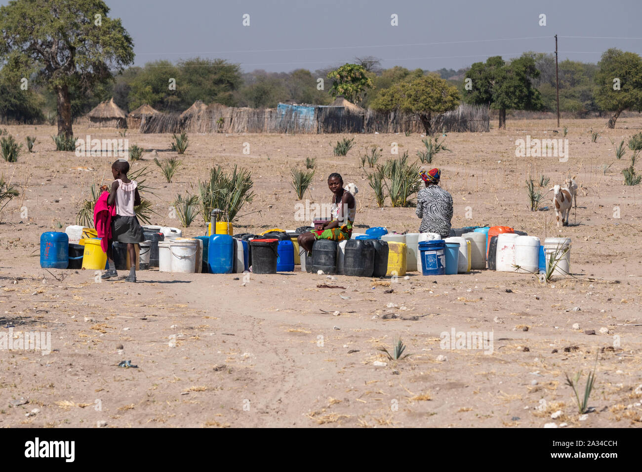 Kapako, Kavango West, Namibia - 29. Juli 2019: Schwarze Frauen vor Ort Füllung Wasser Kanistern an einem Gut in ländlichen Namibia in der Nähe von Kapako, Namibia. Stockfoto