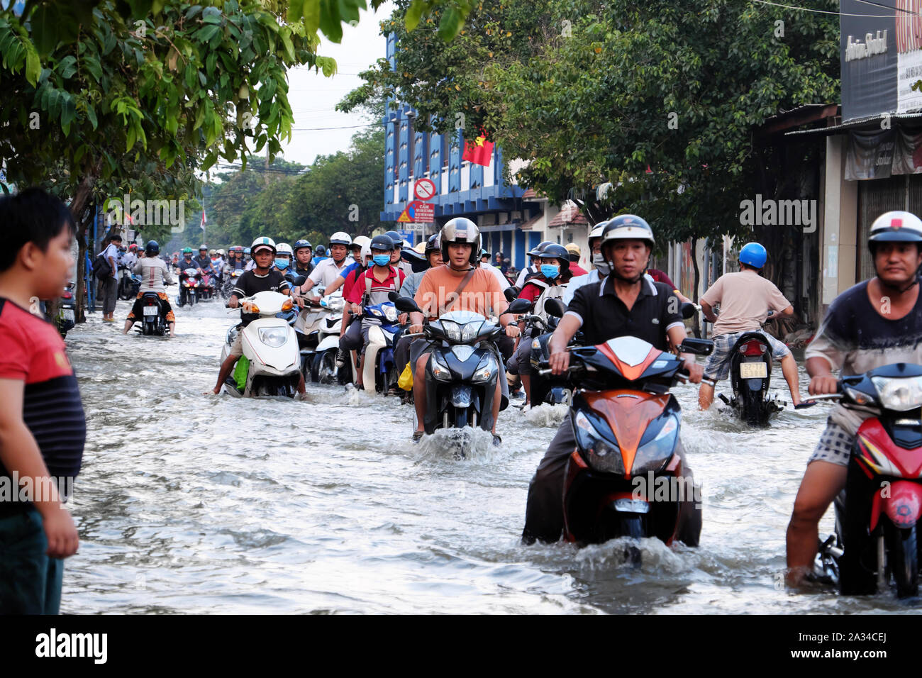 HO CHI MINH CITY, VIETNAM - Sept 30, 2019: Masse von Menschen in Asien große Stadt fahren Motorrad Kreuzung überschwemmte Straße bei Flut am Abend, Fahrzeuge Stockfoto