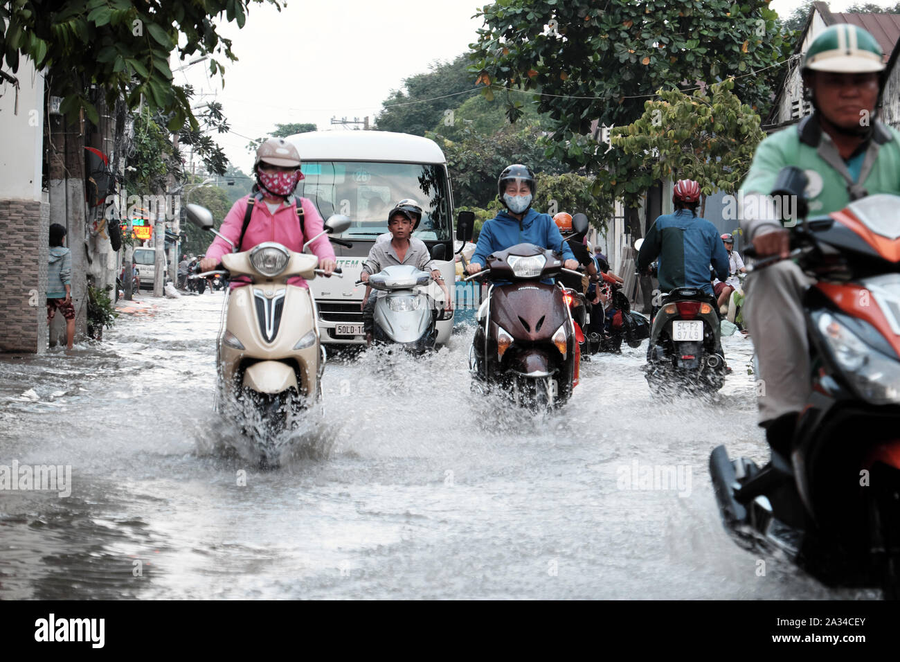 HO CHI MINH CITY, VIETNAM - Sept 30, 2019: Masse von Menschen in Asien große Stadt fahren Motorrad Kreuzung überschwemmte Straße bei Flut am Abend, Fahrzeuge Stockfoto