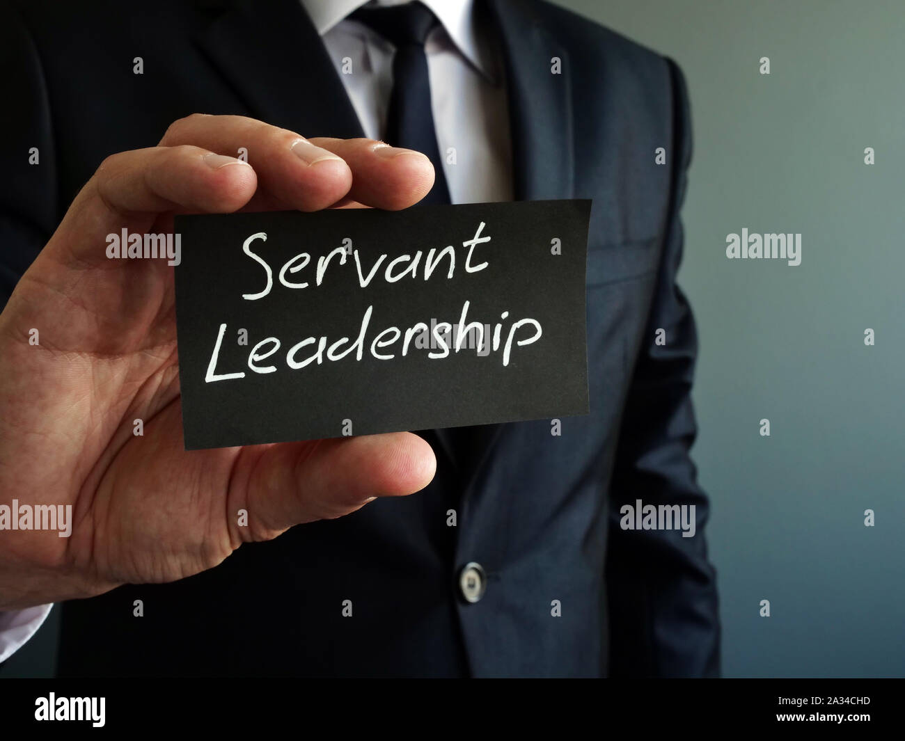 Servant Leadership Konzept. Schwarz Stück Papier in den Händen. Stockfoto