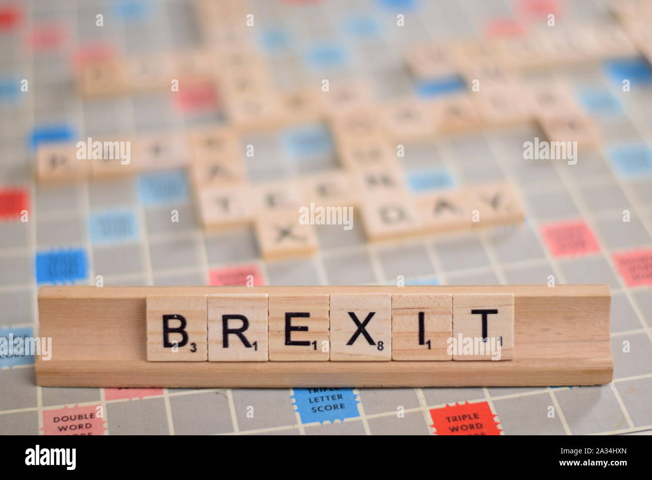 Das Wort "BREXIT" (Aktuelle britische Ausfahrt aus der EU) in Holz- Scrabble Fliesen auf einem Baugruppenträger. Hintergrund ist ein Vintage board, unscharf, mit kopieren. Stockfoto