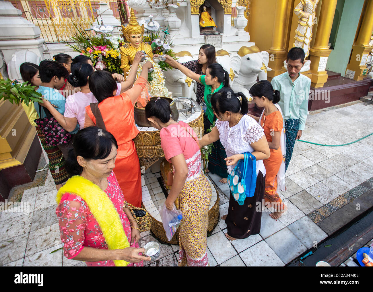 Menschen gießt Wasser auf Buddha Statue am Festakt in der Shwedagon Pagode in Yangon, Myanmar. Stockfoto