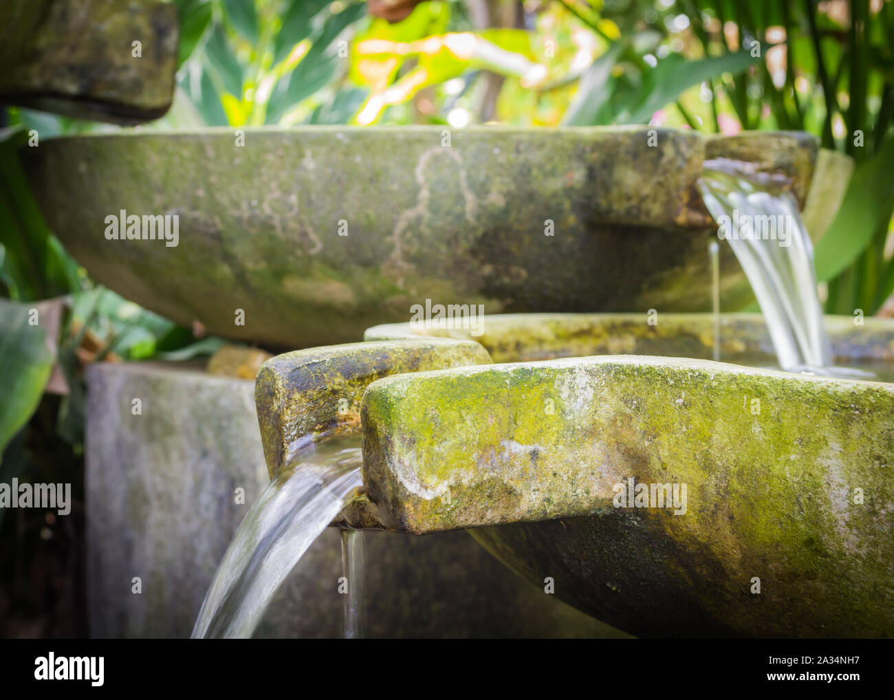 Fließende Wasser vom Becken aus Stein im Garten Stockfoto