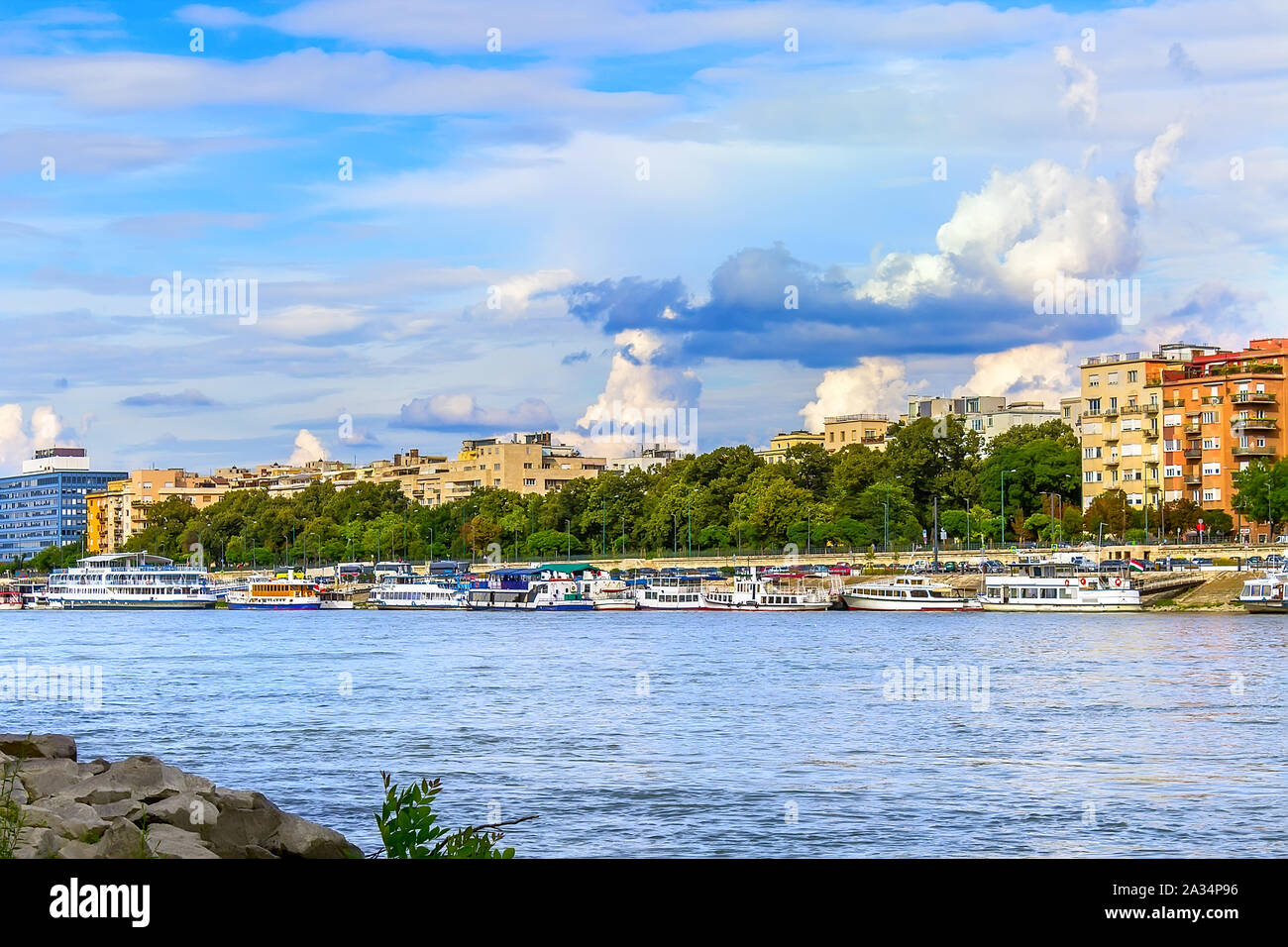 Donau Ufer mit stehendem Motor Schiffe mit attraktiven Wolken, am Ufer mit wachsenden Bäumen und Gebäuden Stockfoto