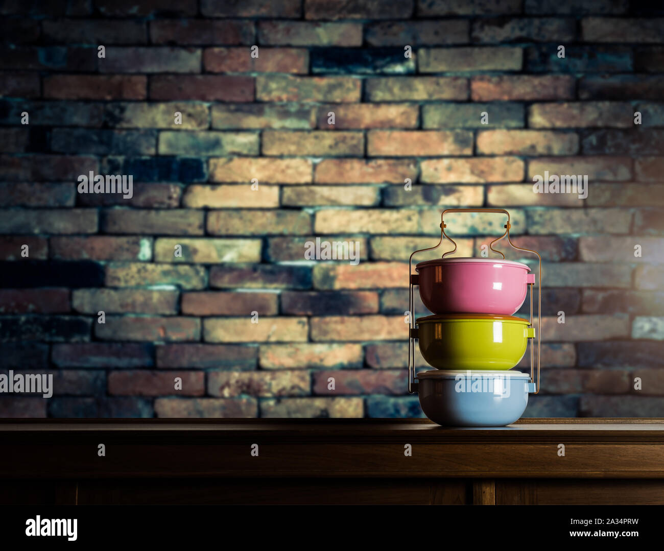 Bunte tiffin Carrier auf Holzschrank mit unscharfen Vintage brick wall gegen warmes Licht Stockfoto