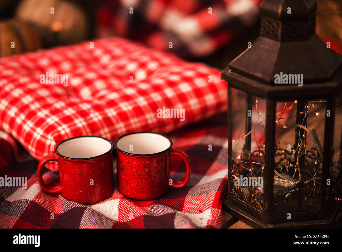 Zwei rote Tassen Kaffee auf karierte rote Abdeckung Herbst Hintergrund. Stockfoto