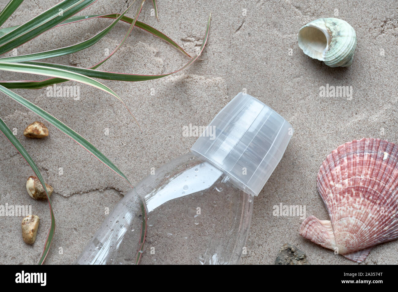 Close-up auf wiederverwendbare Flasche an einem Sandstrand aufgegeben. Die Verschmutzung ist schädlich für die marine Leben. Umweltkonzept. Verbot single use Kunststoff Stockfoto