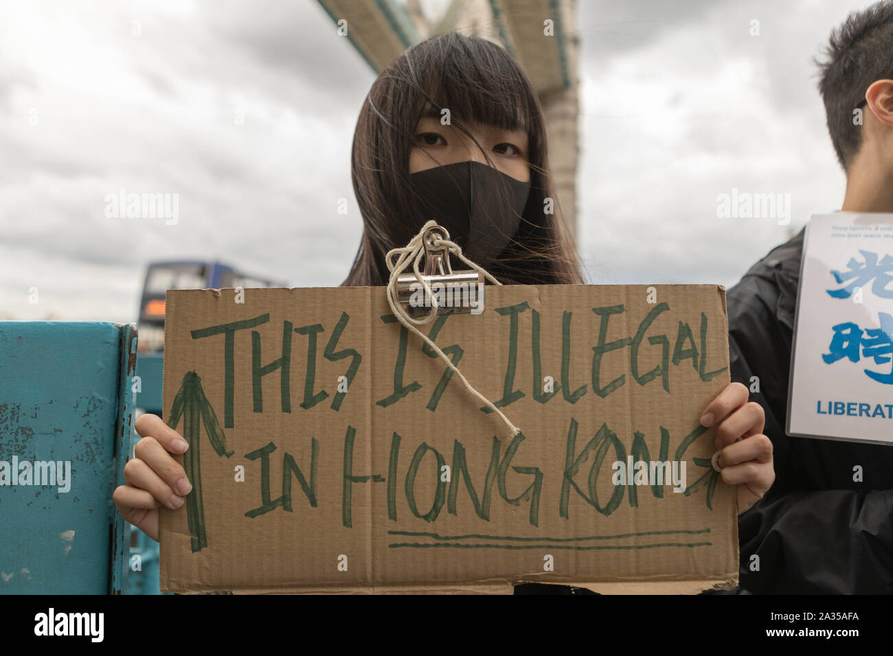 London, Großbritannien. 5. Okt, 2019. Der chinesische Künstler Badiucao und Unterstützer melden Sie die Hände in einer menschlichen Kette, eine Übersicht der Solidarität mit den Demonstranten in Hongkong. Die Lennon-mauer Flagge symbolisiert Hong Kongs Kampf für die Freiheit ist auch symbolisch angehoben. Penelope Barritt/Alamy leben Nachrichten Stockfoto